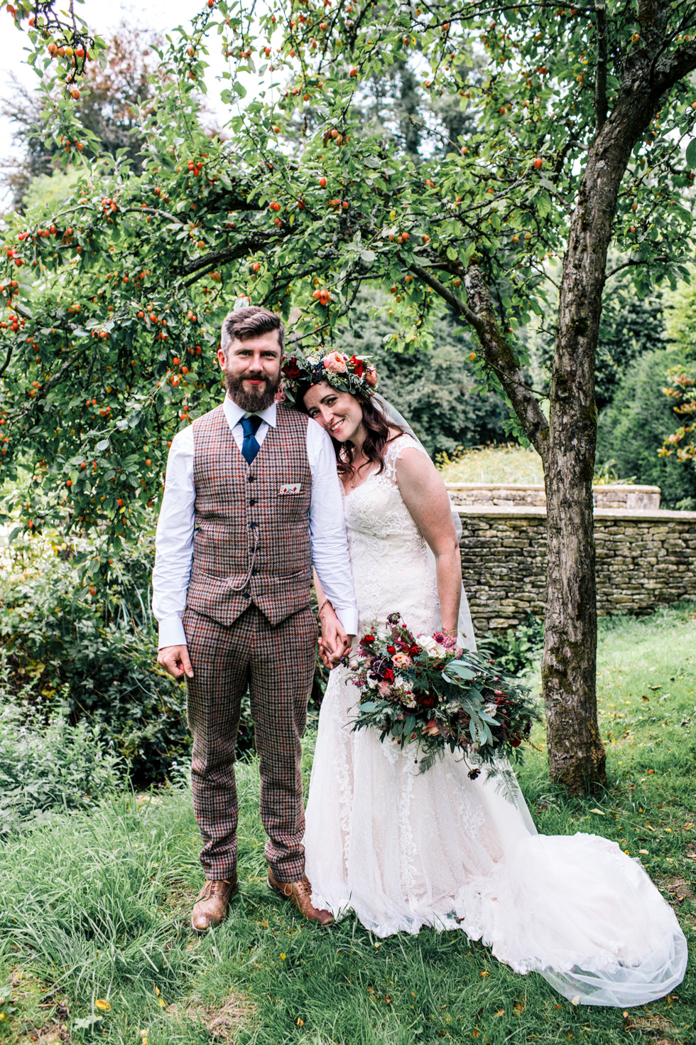 bride and groom portrait session under an apple tree outdoors at Owlpen Manor Festival Wedding