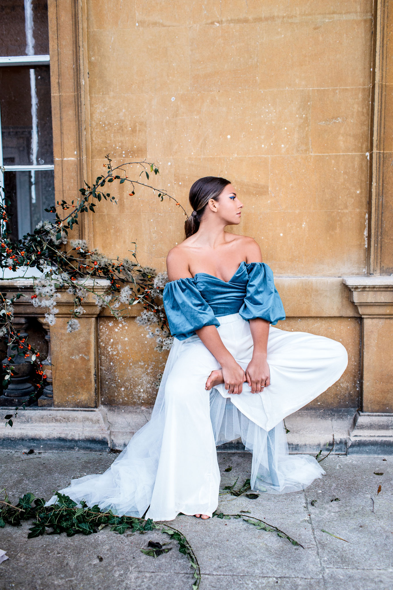 bride wearing blue velvet asos top for small wedding elopement and white trousers with a long veil in bath