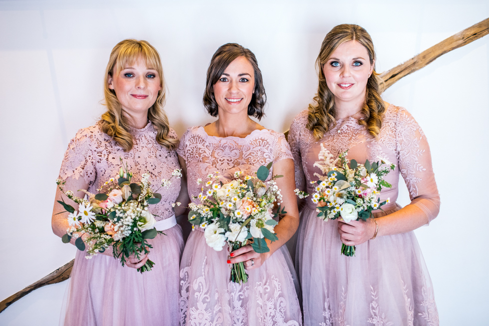 bridesmaids in blush dresses with rustic hand tied wedding flowers