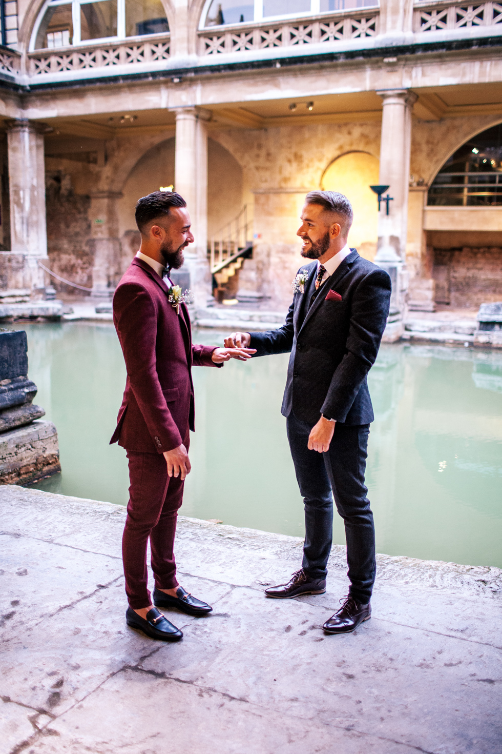 groom and groom exchanging rings at roman baths