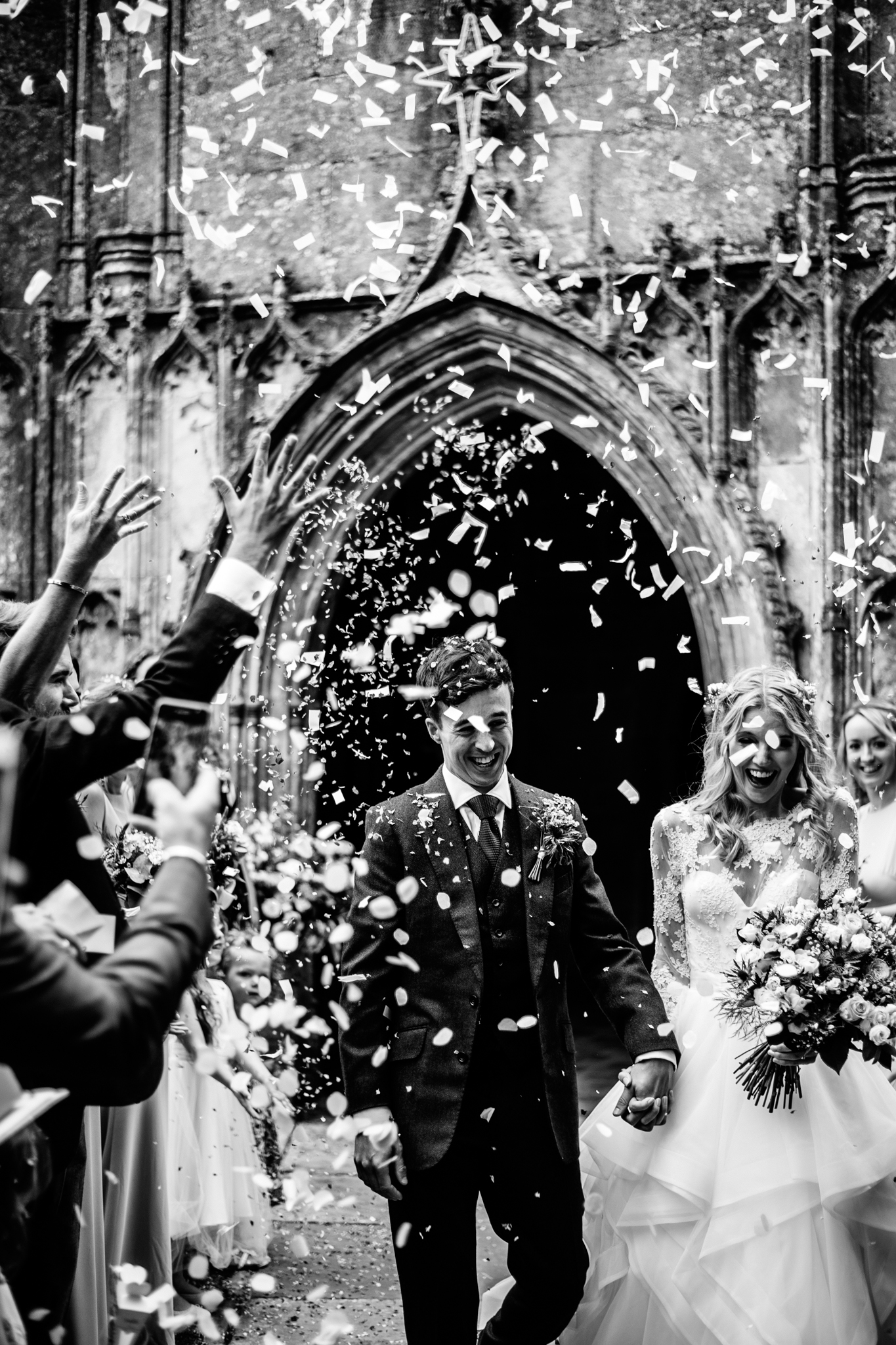 Confetti cannon being launched outside church to create epic photograph with loads of white confetti