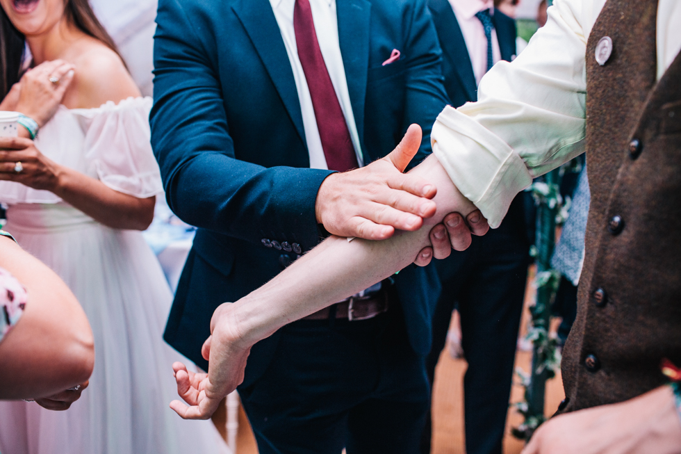 temporary tattoos being stuck on wedding guest arm at festival wedding