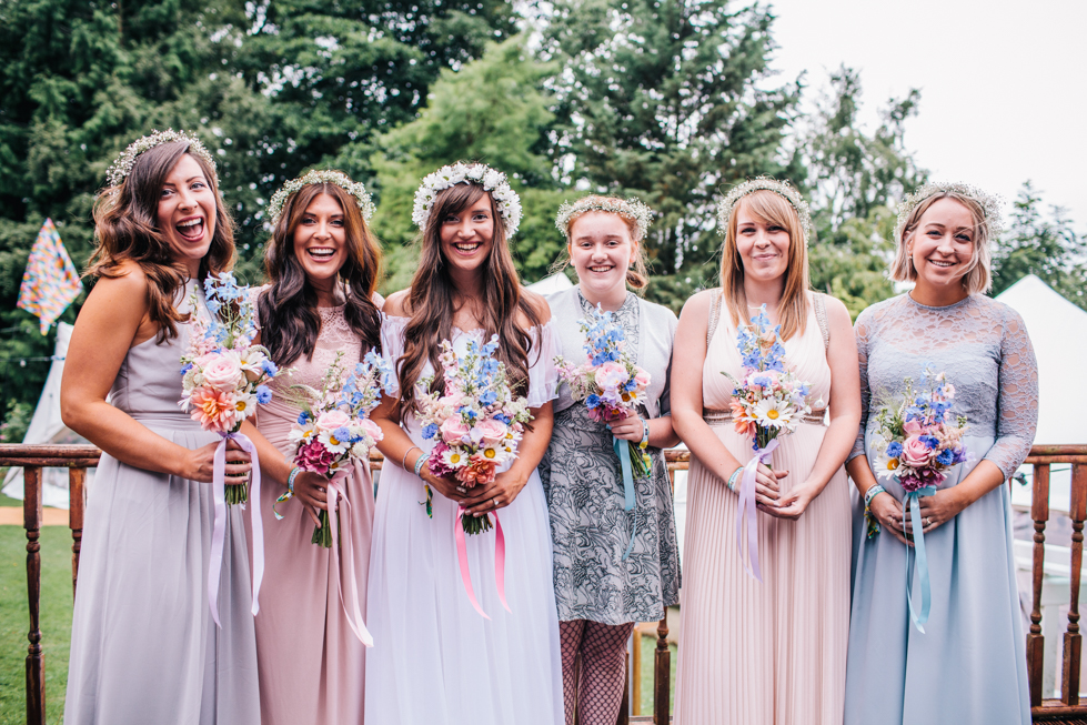 bride and bridesmaids standing together for group shot before wedding ceremony