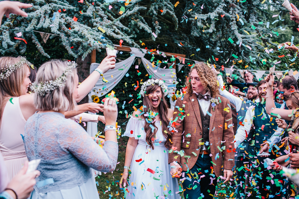 bright confetti being throw at outdoor wedding ceremony 