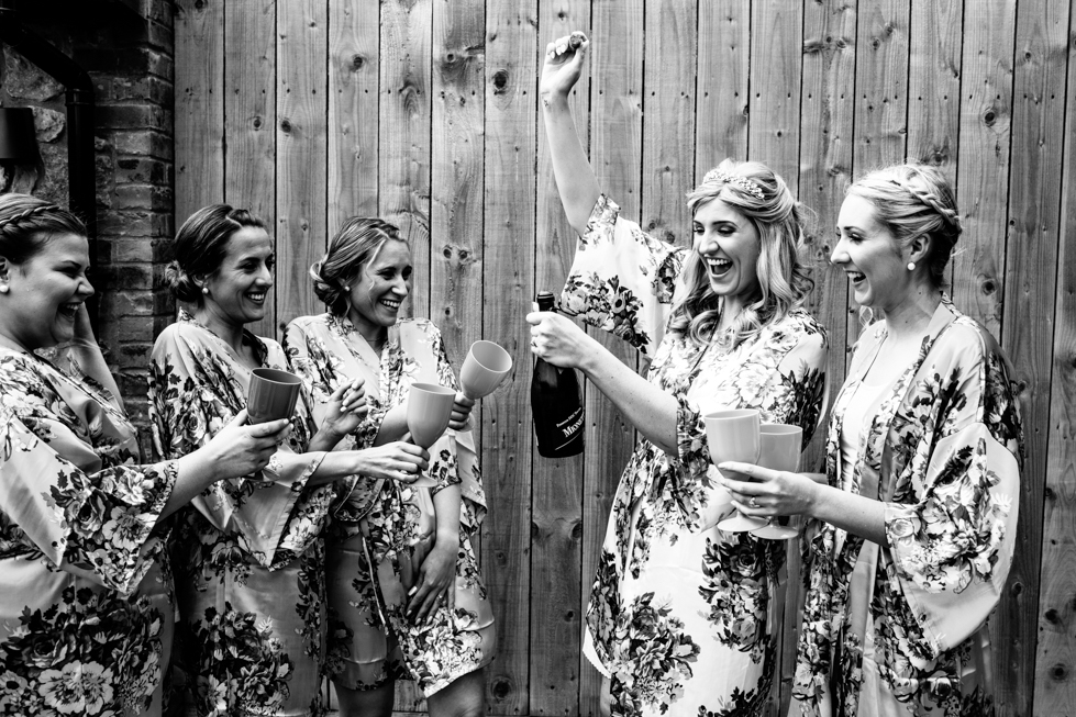 bride and bridesmaid opening champagne together