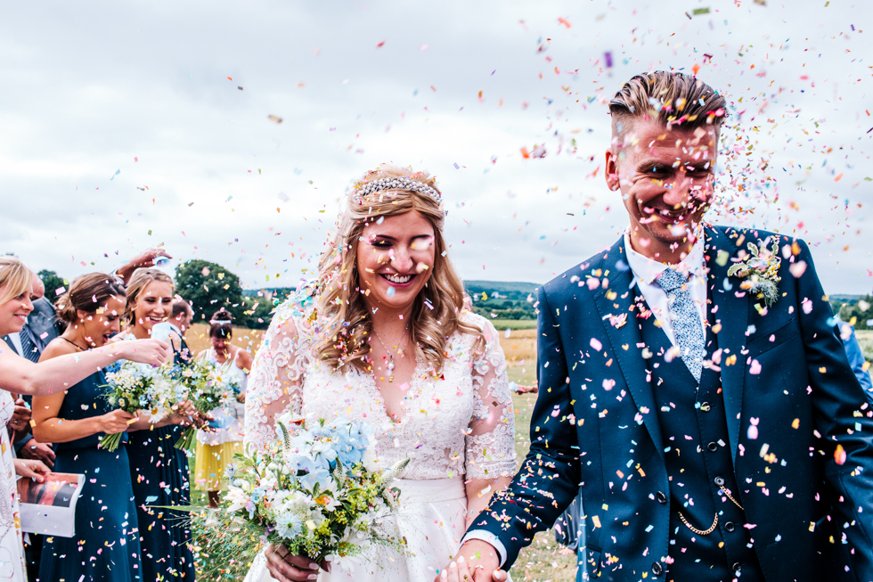 massive amounts of confetti being thrown over the bride and groom at Quantock Lakes