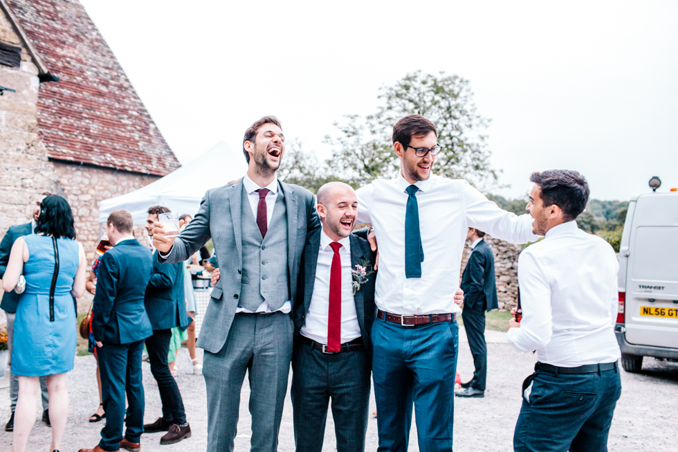 two really tall guys and two short guys standing next to each other for comparison at wedding