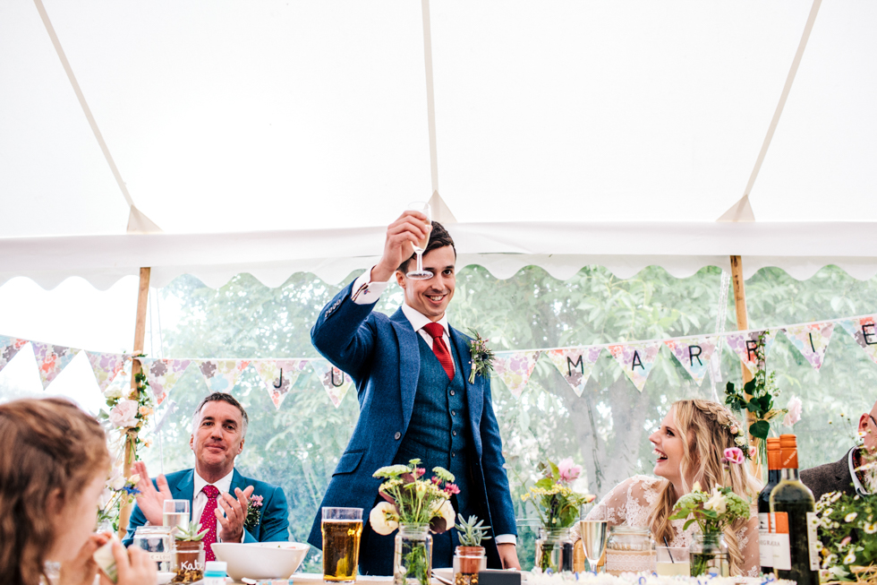 groom raising his glass to his wedding guests during speeches