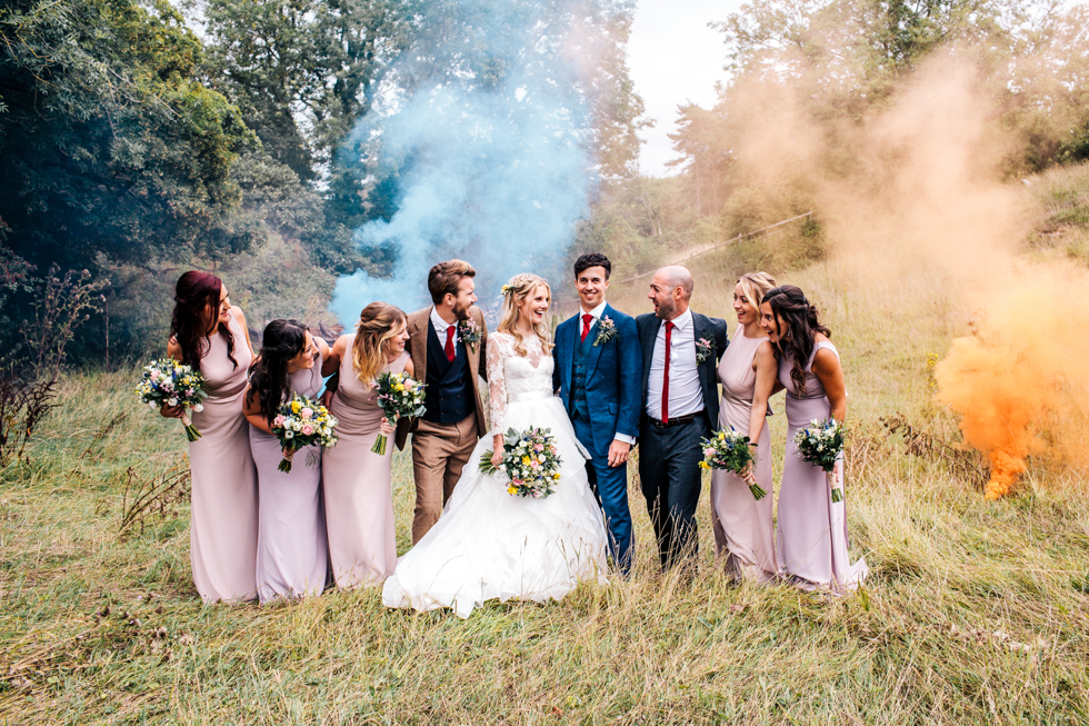 blue and orange stylised photo of smoke bomb with bride groom and friends at a wedding in Mells frome