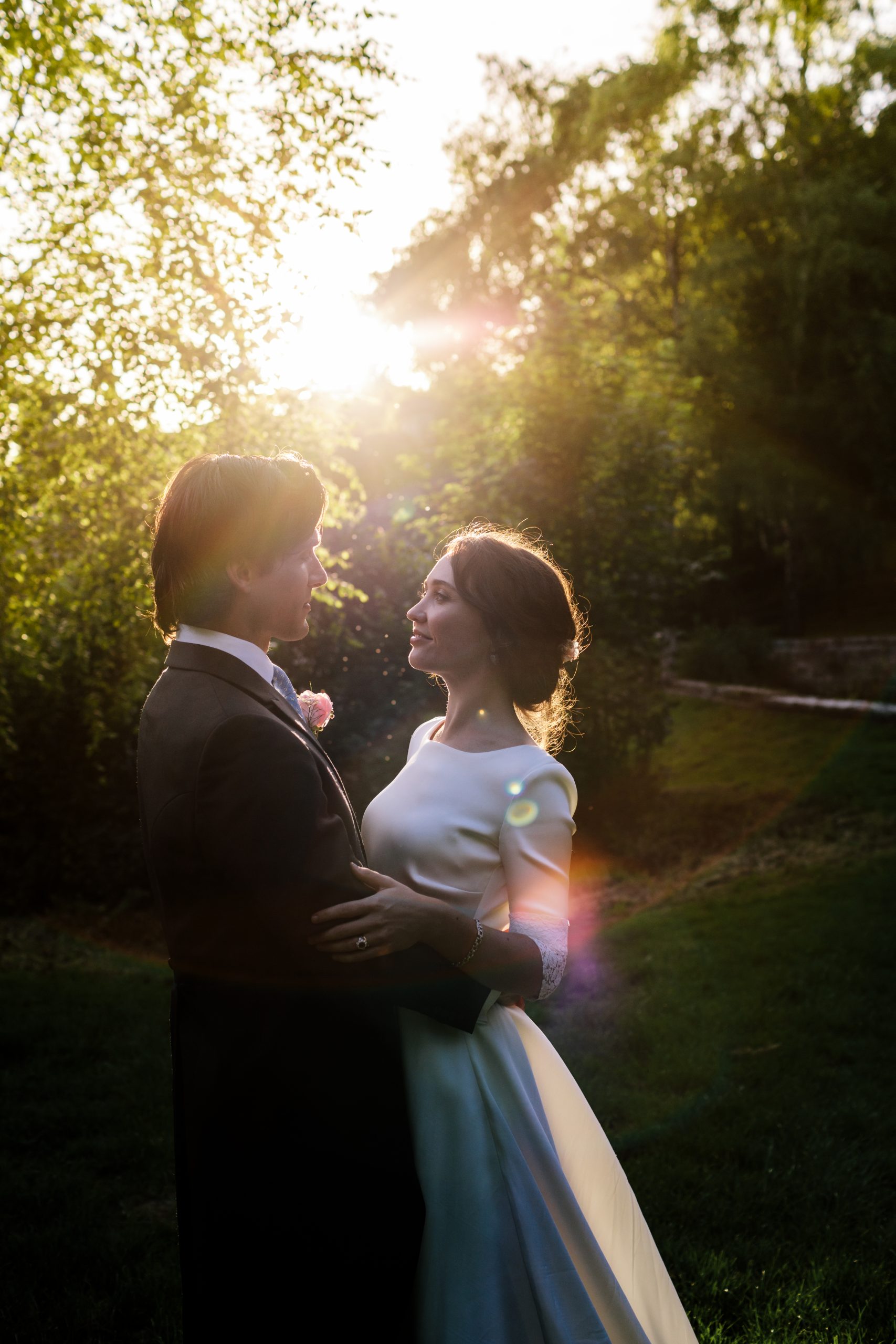 French wedding at Owlpen Manor, bride is being held by groom in the evening golden sunlight