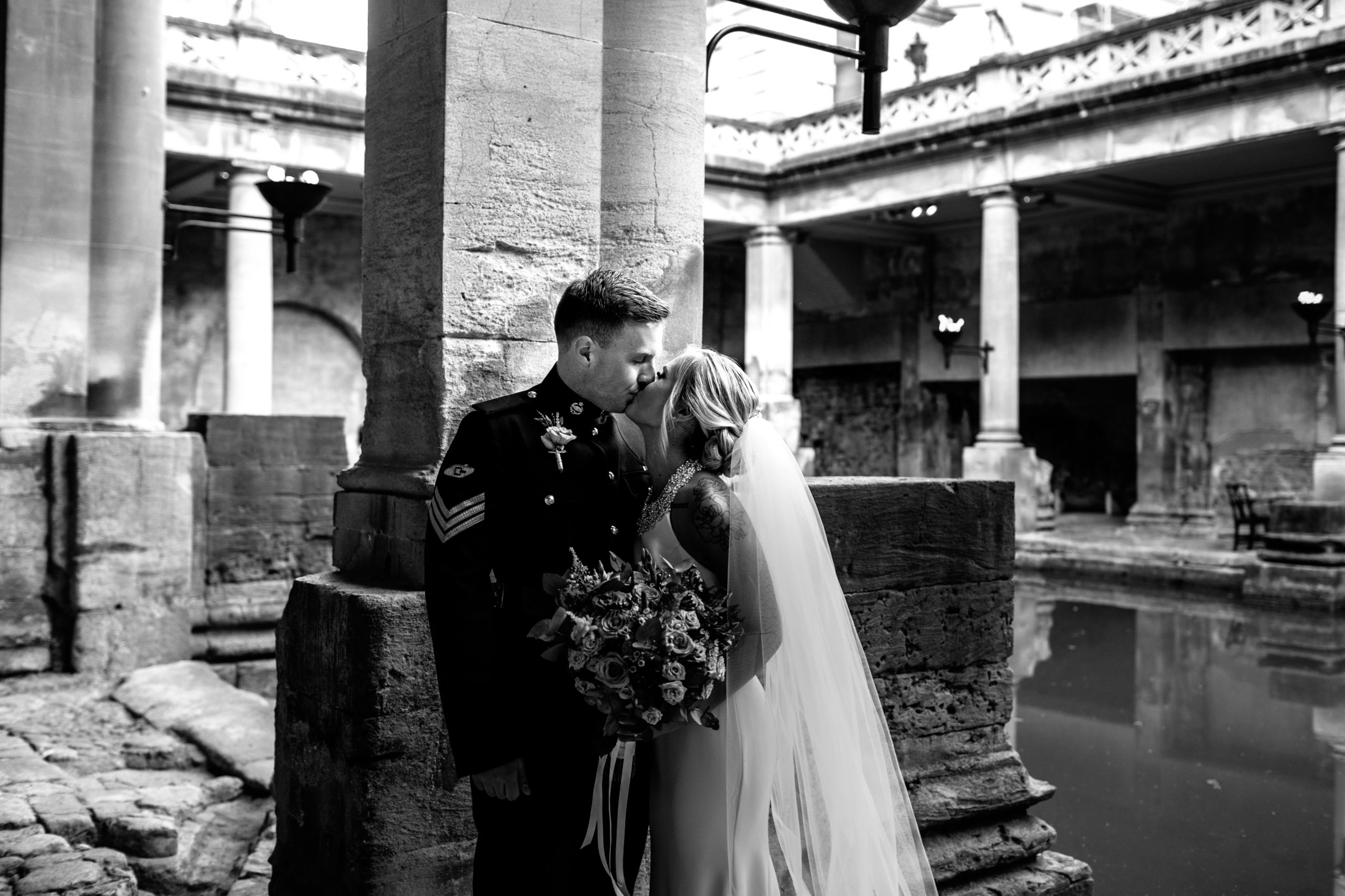 Couple kissing at the Roman Baths after getting married