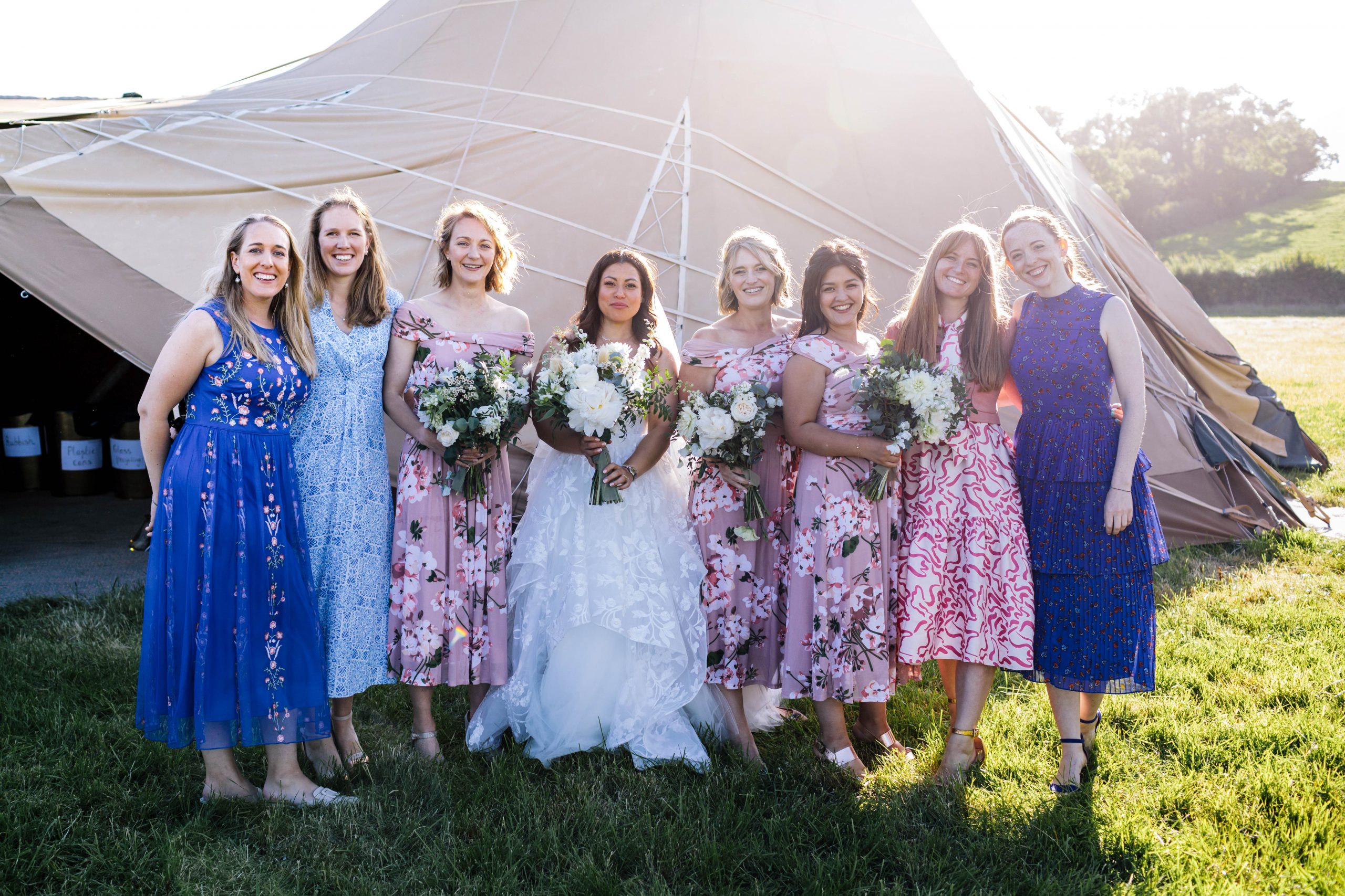 bridesmaids and bride standing in front of tipi in the sunshine in Bath