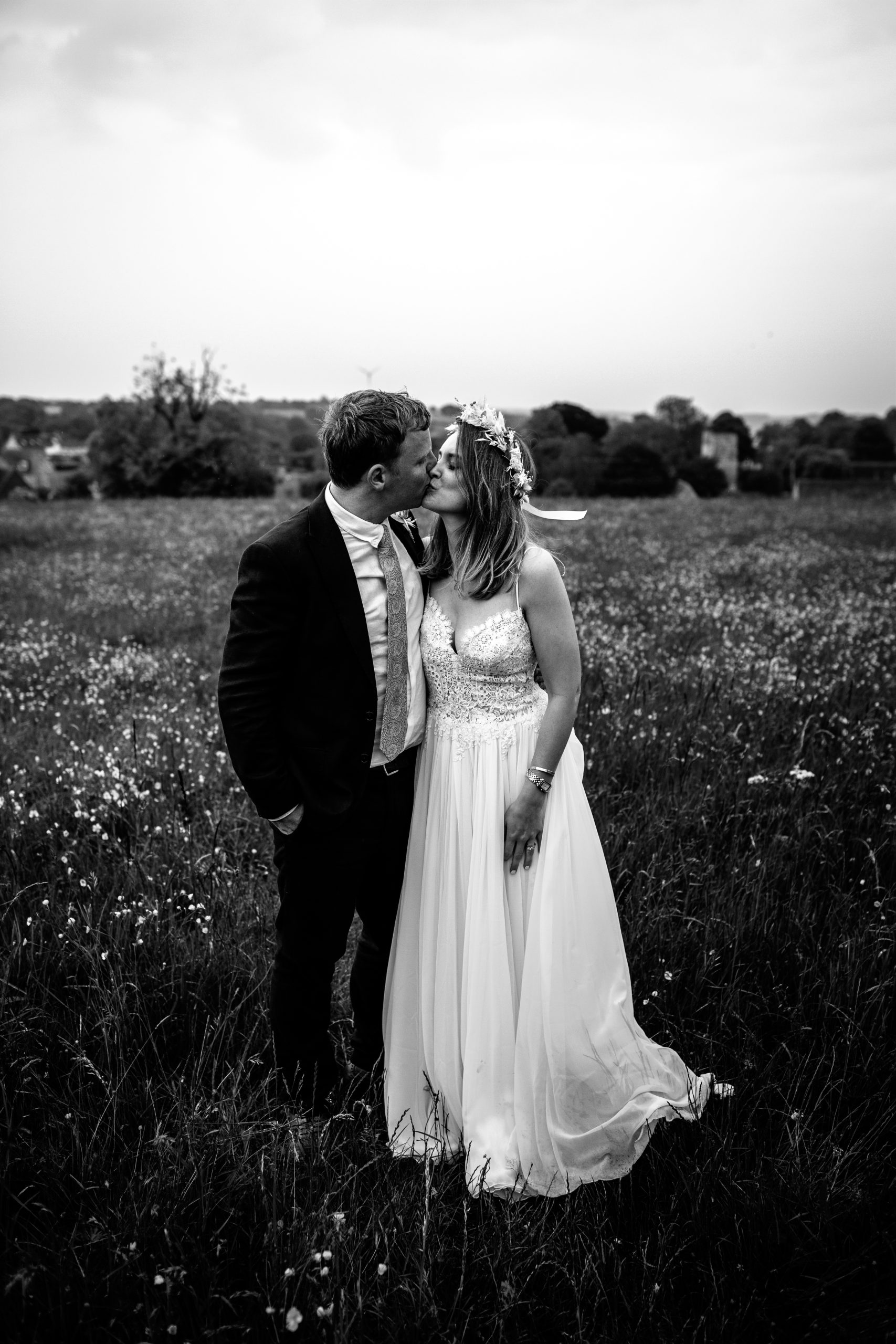 black and white photo of couple embracing in field